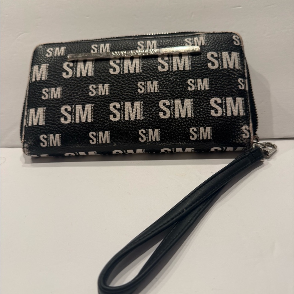 Steve Madden logo zip-around wristlet wallet in black with white branding.